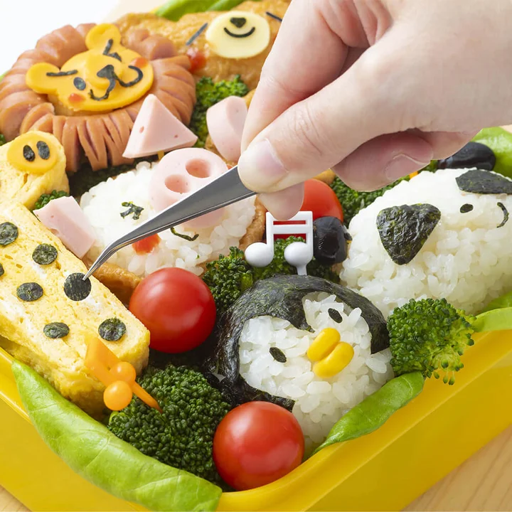 ピンセットで海苔のパーツを置いてキャラ弁を仕上げているところ