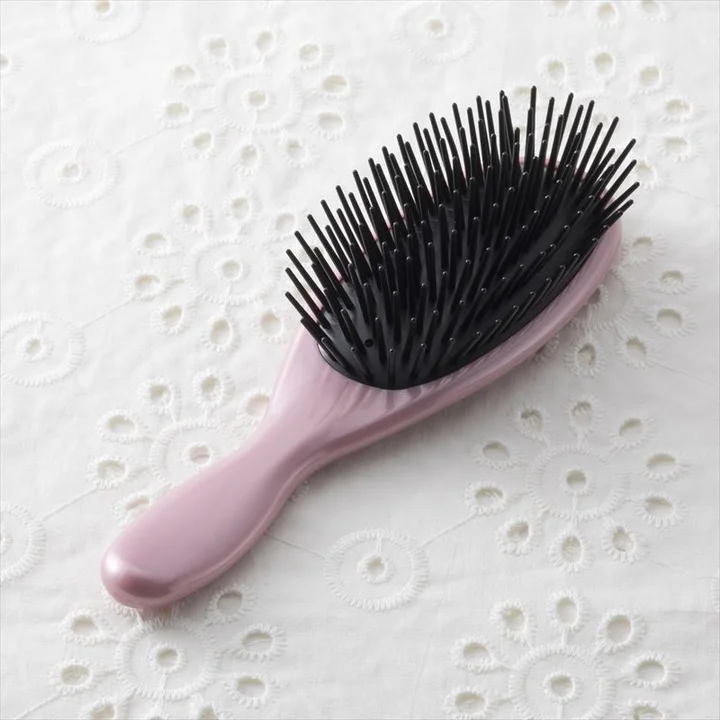 貝印 ポリヘアブラシの本体 ピンクの柄と黒いポリエチレン製の先丸ピン