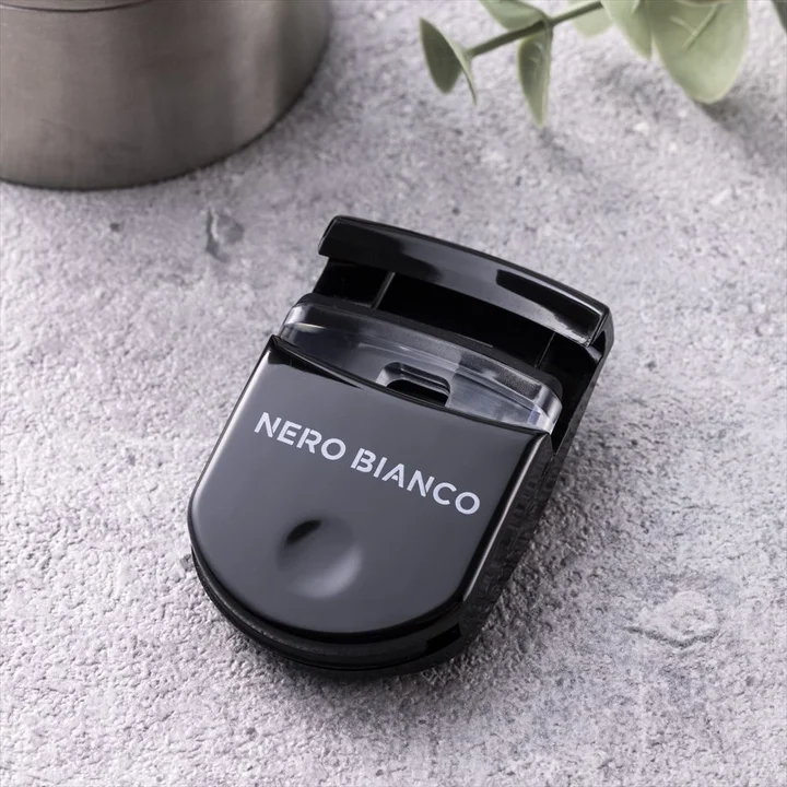 NERO BIANCO コンパクトアイラッシュカーラー。黒い樹脂製の小型ビューラー