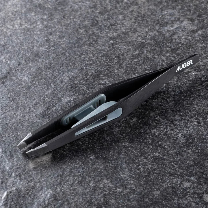 AUGER 毛抜きの先端の拡大。斜めにカットされた先端と、本体に付いたグレーのキャップ
