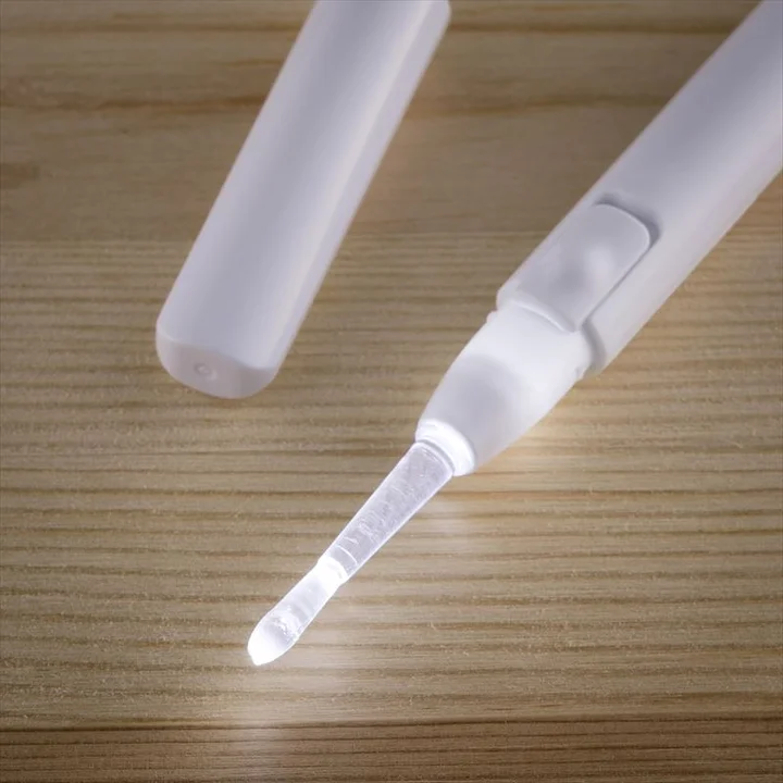 ライト付粘着耳かきのLEDが点灯した状態　半透明で平たいヘラ状の粘着チップが光っている