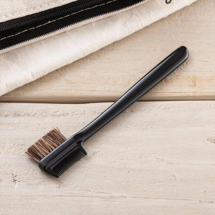 貝印 cosmeup クシ付マユブラシを木のテーブルとポーチの横に置いた状態