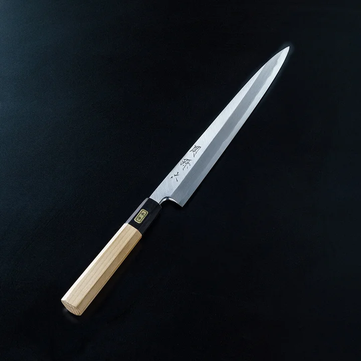 関孫六 青紙鋼(青紙2号) 柳刃 210mm の全体。黒い背景に、白木の八角柄と黒い水牛角の口金