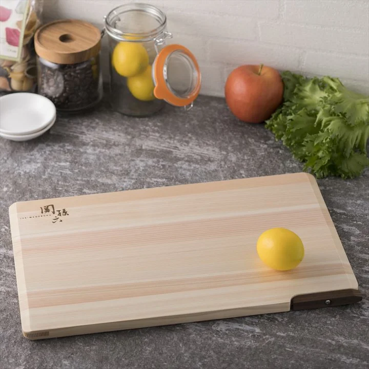 関孫六 桧まな板 スタンド付 360×200 をキッチンに置き、レモンやりんご、レタスを並べた使用イメージ
