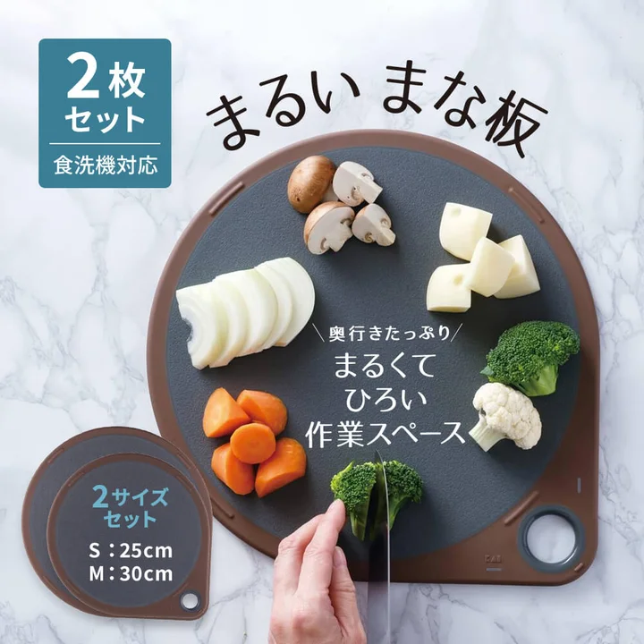 貝印 まるいまな板 2枚セット（S25cm・M30cm）の商品画像。食洗機対応と記載され、丸い面に野菜が並んでいる