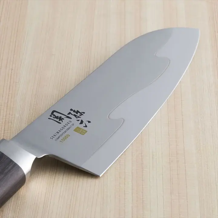 関孫六 15000ST 三徳包丁 165mm の刃のアップ。「SEKIMAGOROKU COMPOSITE&COBALT SP 15000」の刻印と金色のULTRA EDGE STマーク、刃の中ほどに波打つ境目の線が入っている