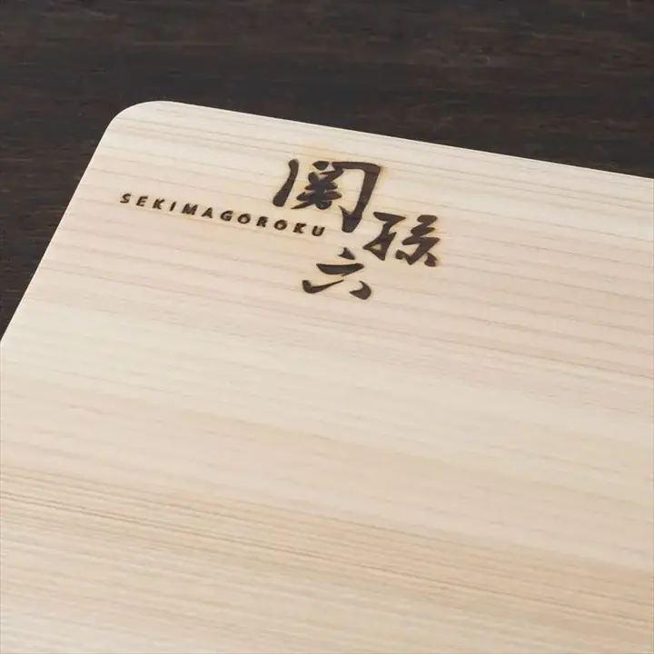 関孫六 桧まな板 450×300mm の角に焼印された「SEKIMAGOROKU 関孫六」のロゴのクローズアップ