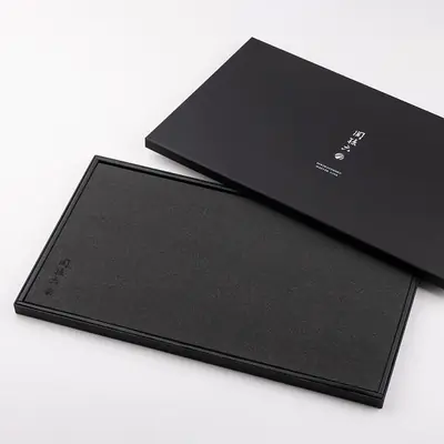 関孫六 マスターラインまな板 L の黒い専用化粧箱と、箱から取り出した黒い合成ゴム製まな板