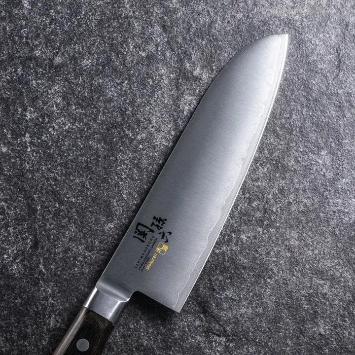 関孫六 木蓮 三徳 165mm の刃のアップ。刃先に沿って波打った刃境の模様が見える